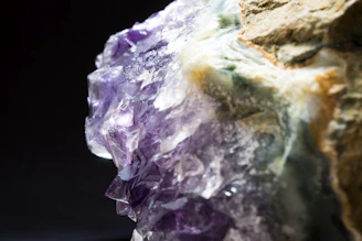 Close-up of a shimmering raw amethyst crystal glowing softly under natural light.