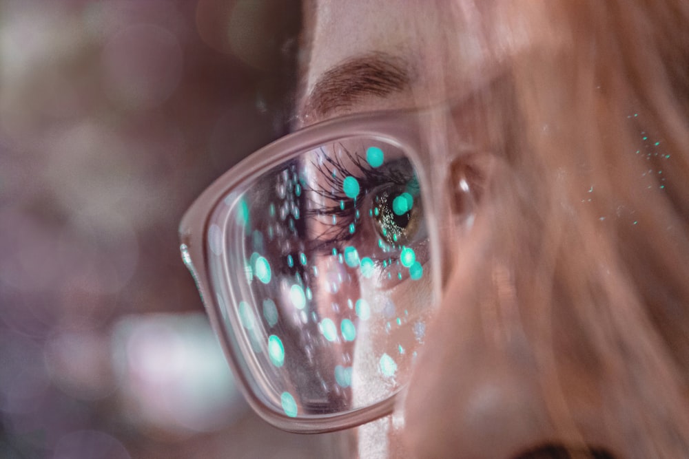 close-up photography of woman wearing Wayfarer-style eyeglasses