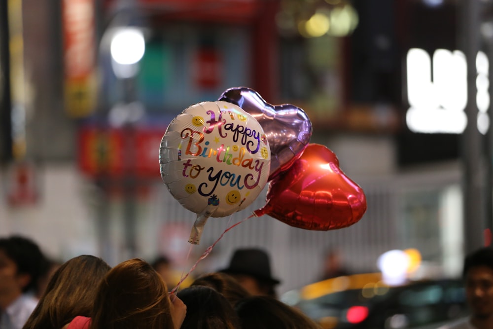 person holding three balloons