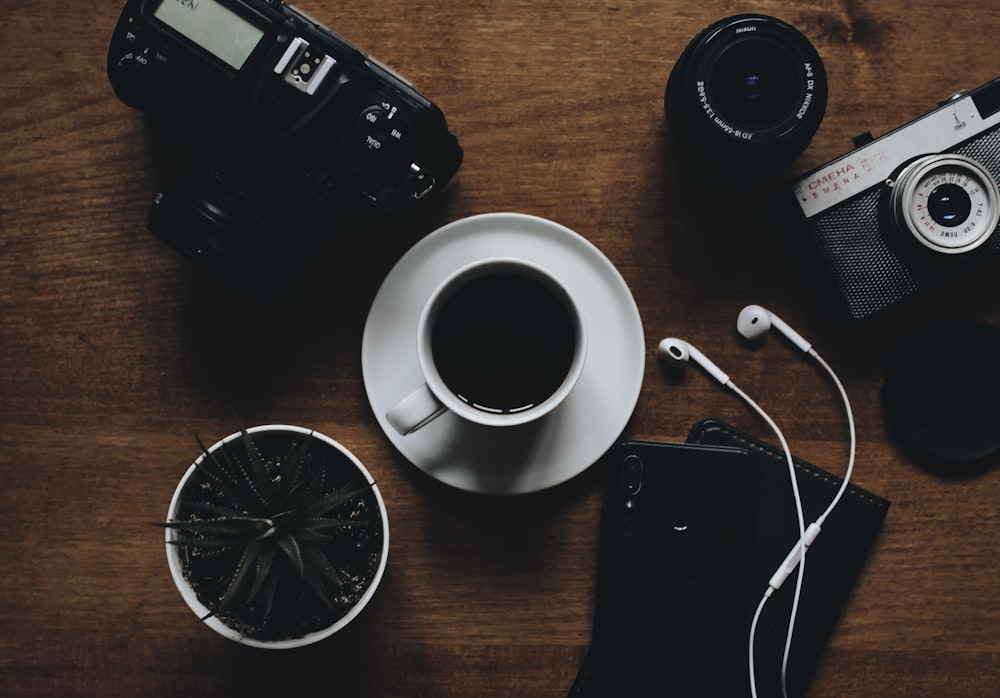 black camera beside cup