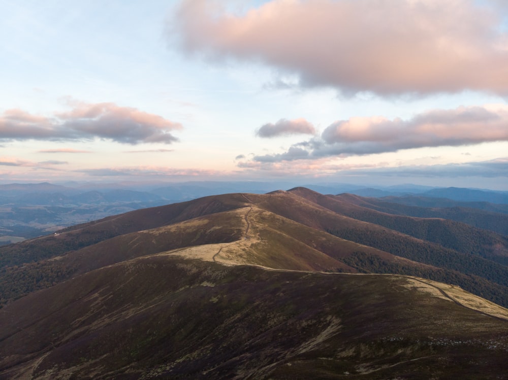 brown mountains under blue and white sky