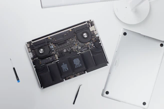 Technician opening a MacBook to replace a faulty battery.