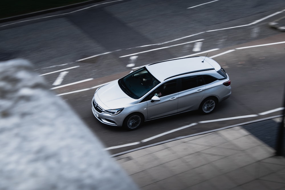 silver SUV traveling on concrete street