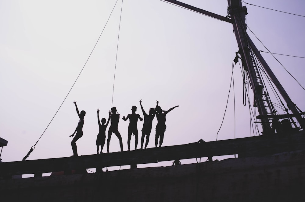 silhouette of people standing near post