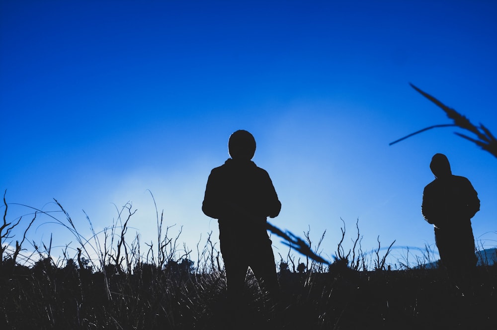 silhouette of 2 person at field during daytime