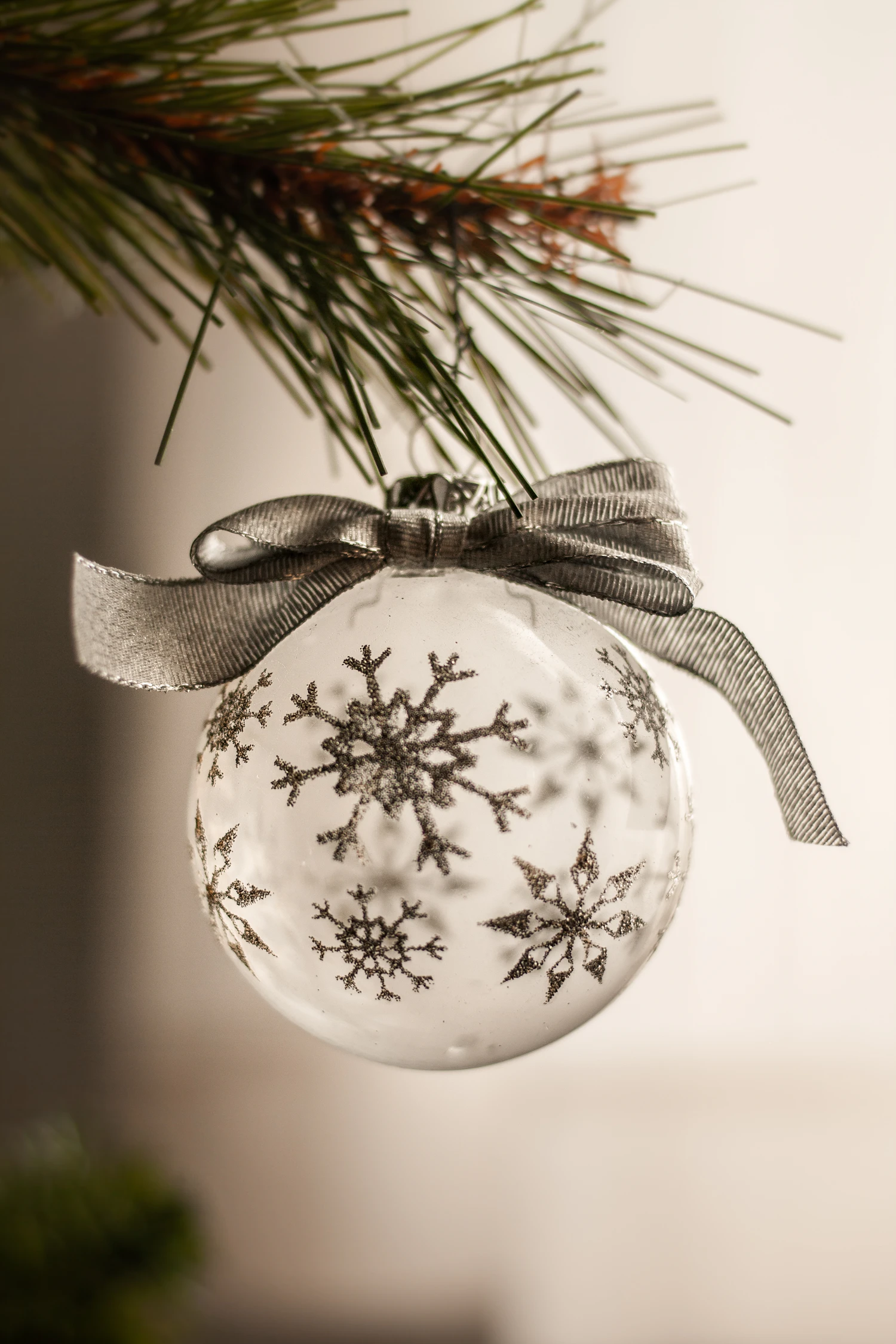 Schneeflocke white glass bauble painted with snowflakes, hung with a silver bow