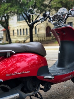 A sleek red automatic scooter parked on a city street in Indonesia.
