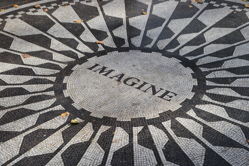 Un mosaico en blanco y negro con la palabra Imagine en él