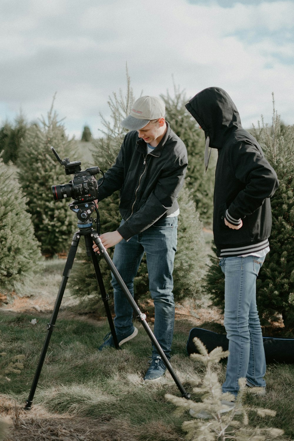 two people standing near camera with tripod