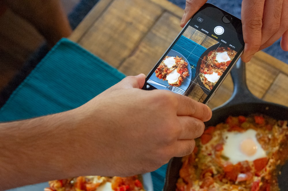 person holding space gray iPhone 6 taking photo of food