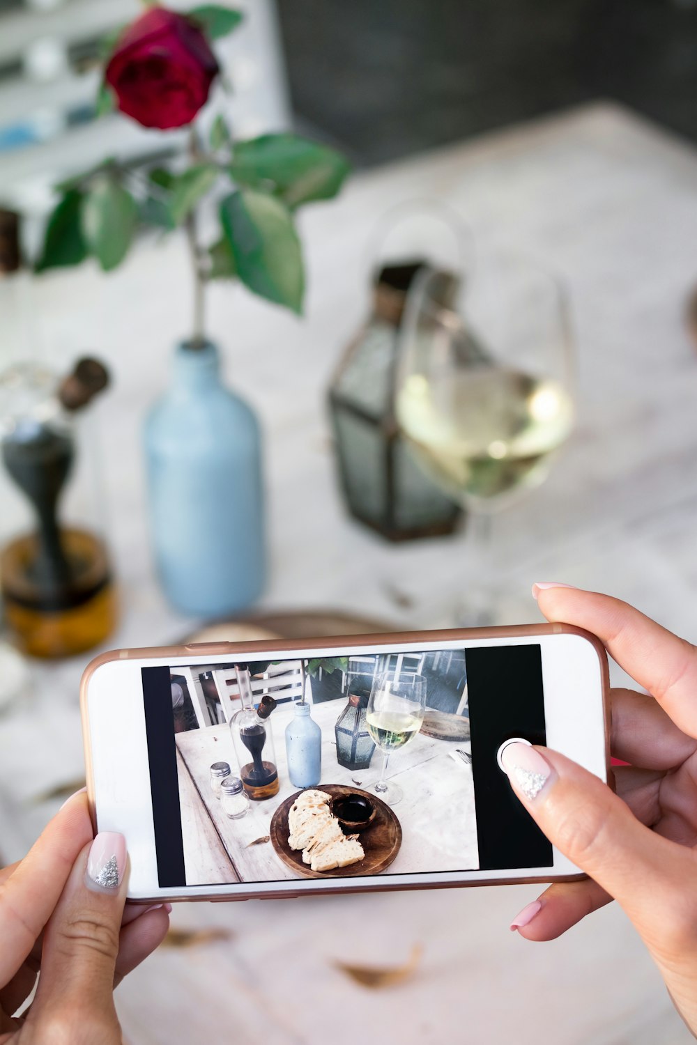 selective focus photography of person holding iPhone taking photo of food