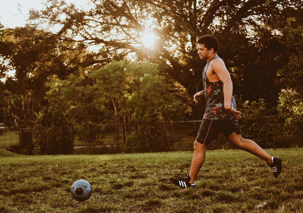 man playing soccer during daytime