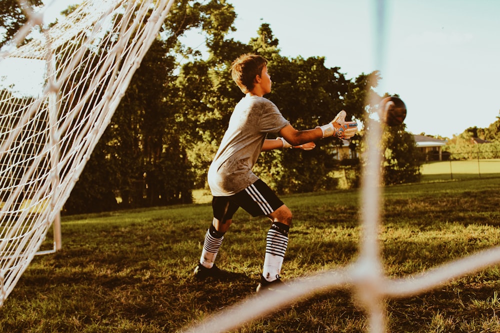 boy standing near net goal