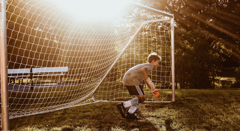 boy standing in front of soccer goal