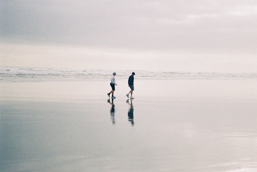 deux personnes marchant à la plage pendant la journée