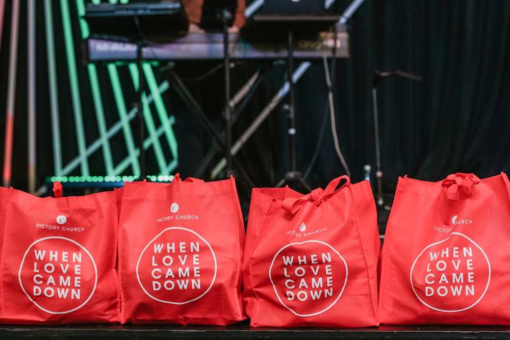 four red fabric tote bags