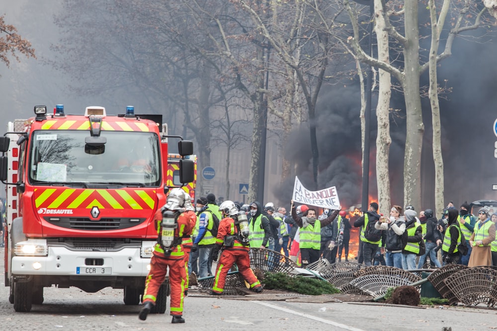 people rally near firefighter during daytime