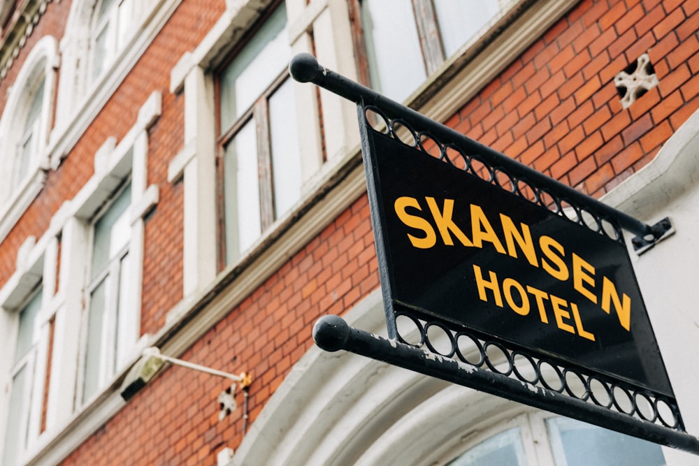 yellow and black Skansen Hotel metal signage