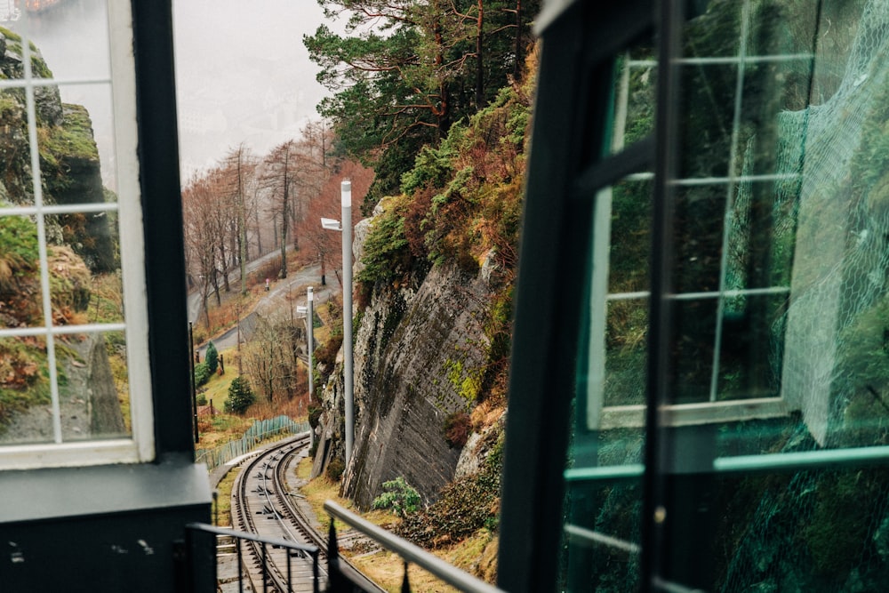 photography of train rail beside cliff during daytime