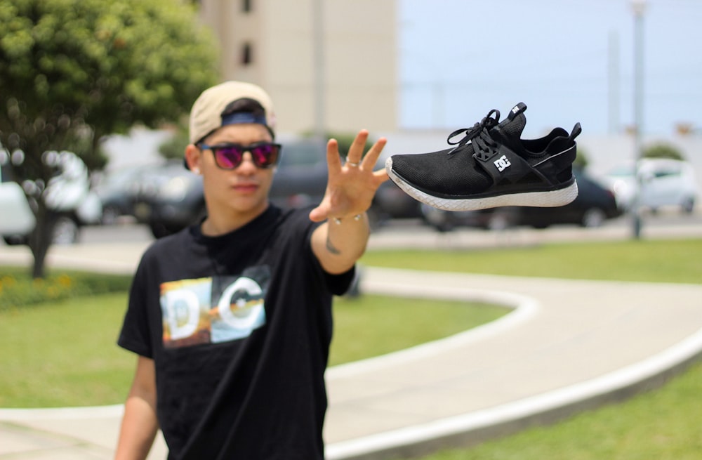 man wearing black shirt near black sneaker