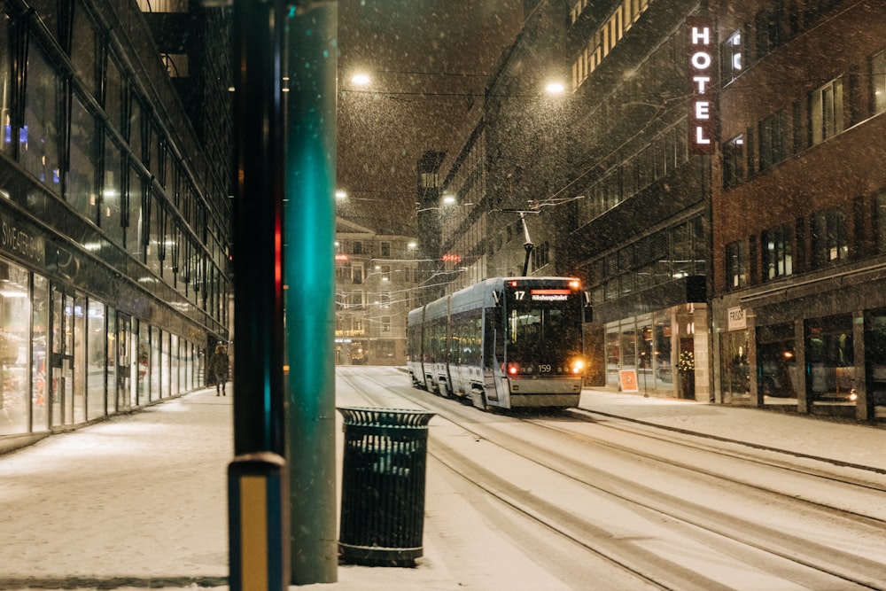 black and grey bus on snow covered road during night time