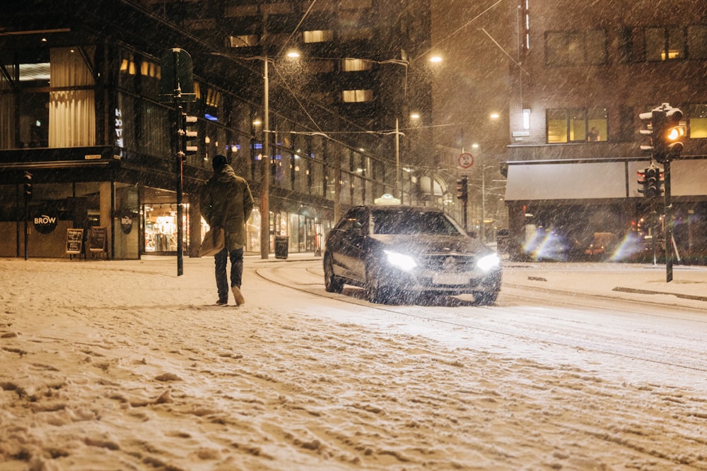 few people walking near road beside vehicle and snow falling down