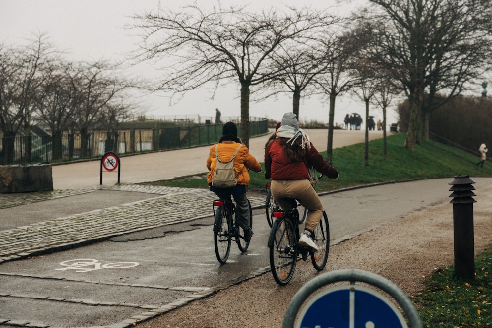 two persons riding on bicycle during daytime