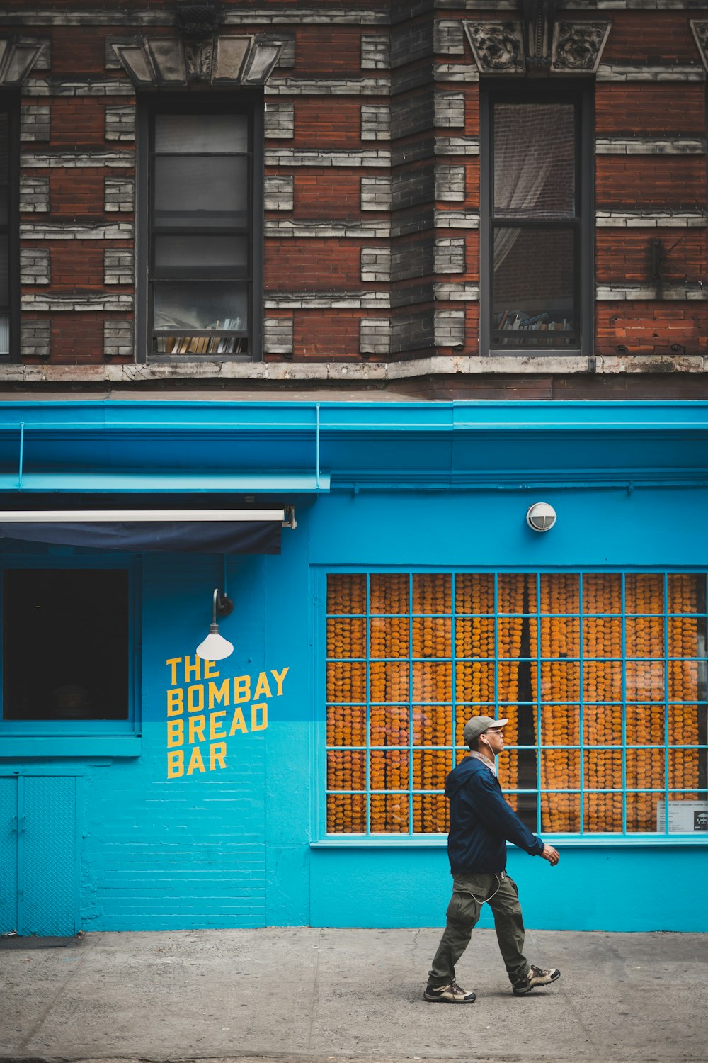 man walking beside 2-storey building