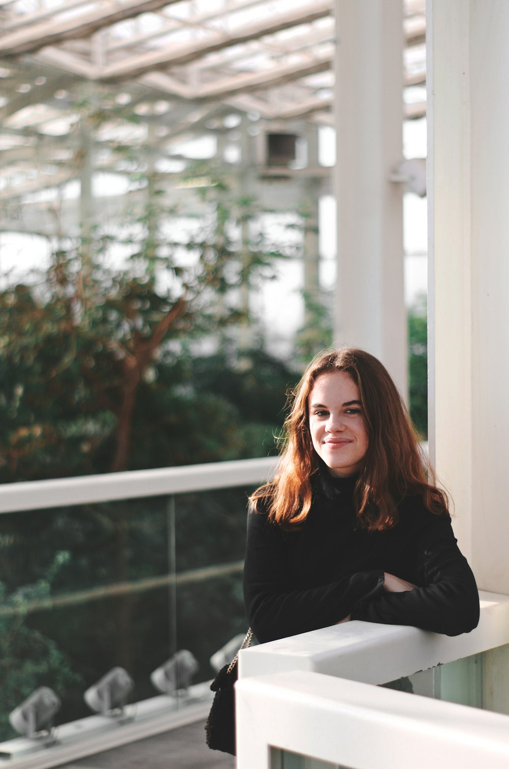 woman leaning on glass railing