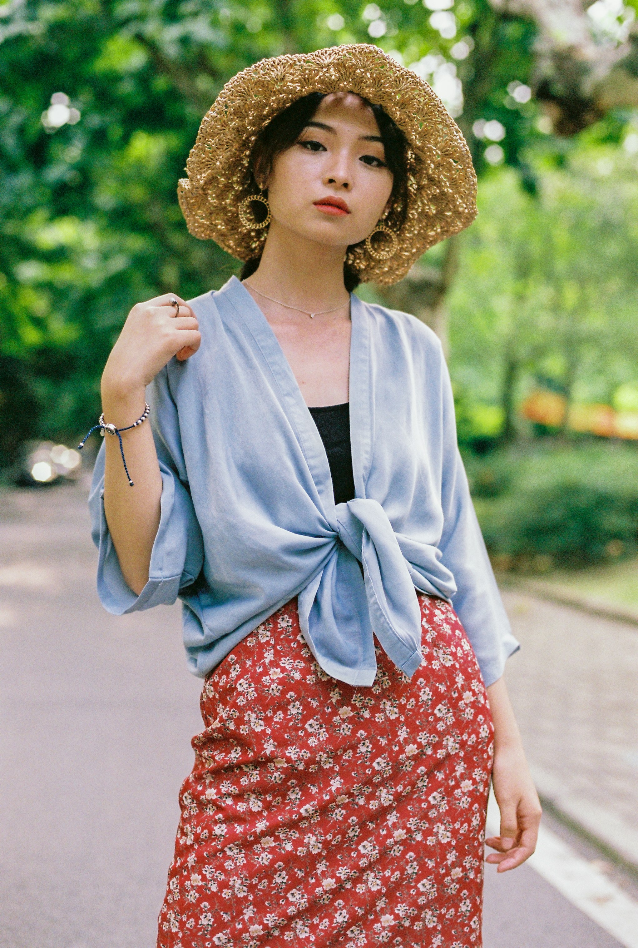 standing woman wearing blue cardigan and red skirt