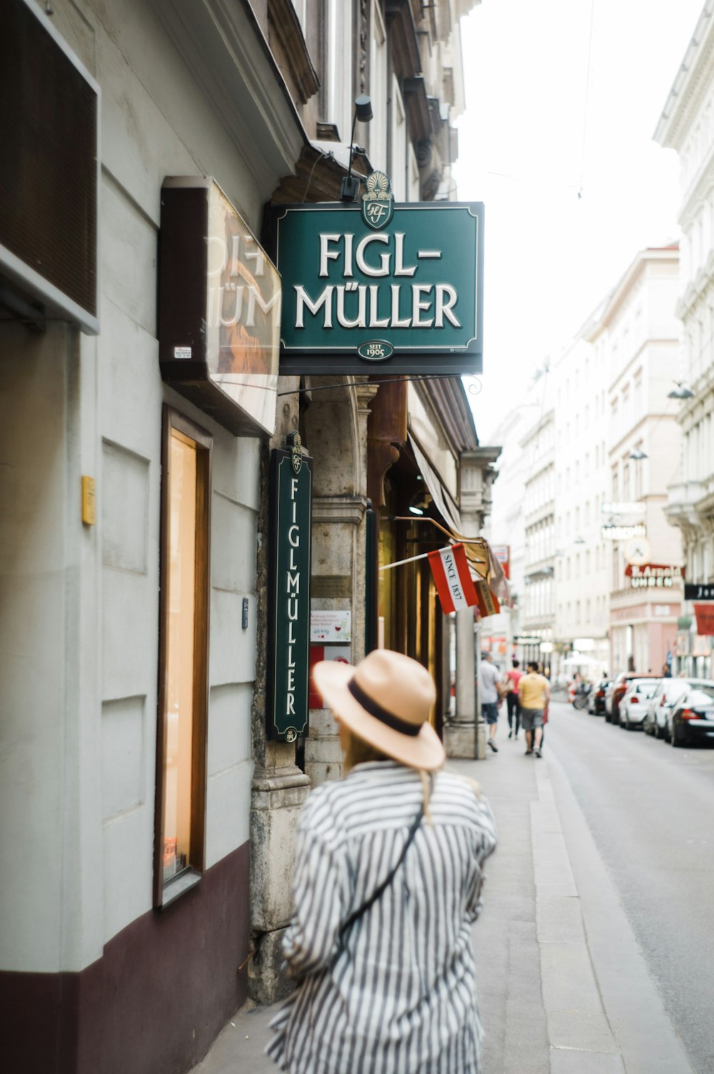 woman walking on street near Figl-muller building during daytime