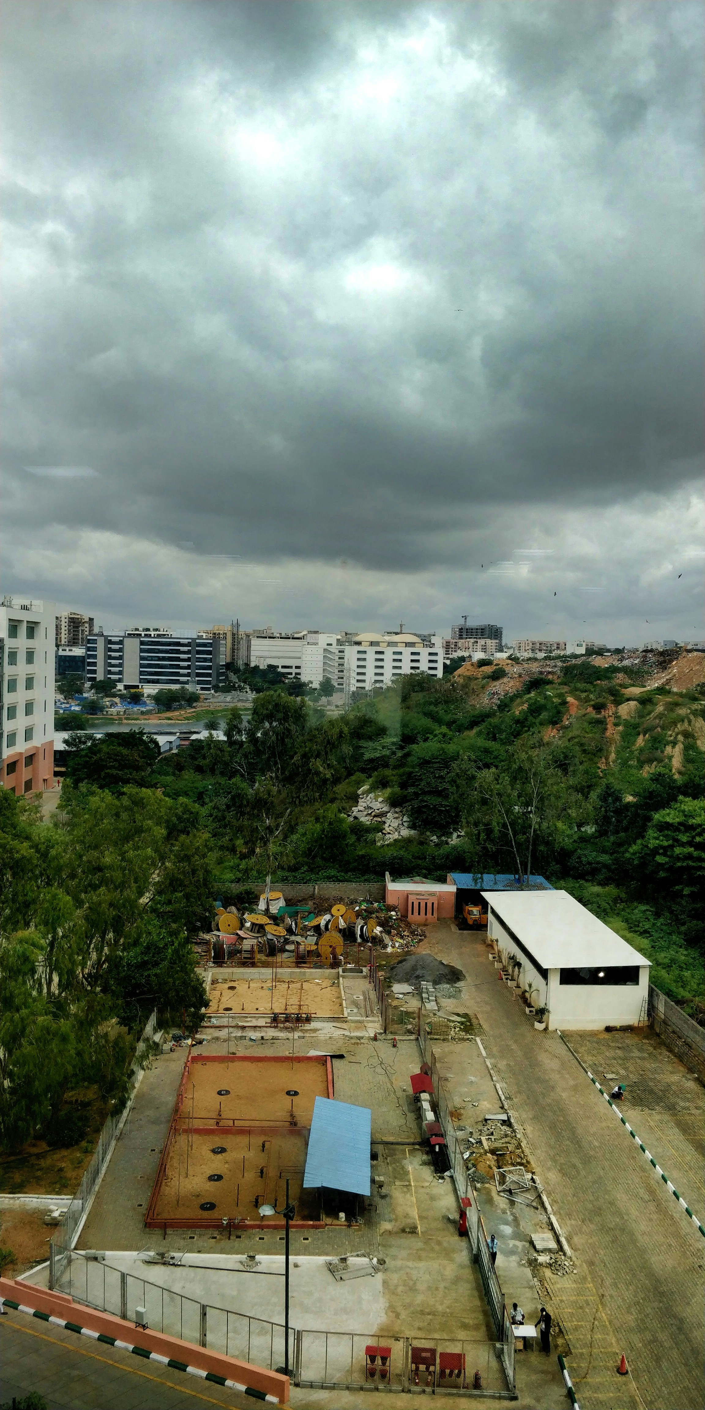 Heavy construction excavation on steep slope, earthmoving equipment, raw terrain, overcast industrial sky