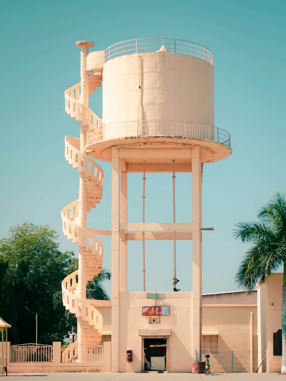 white water preserve tank beside white concrete building during daytime