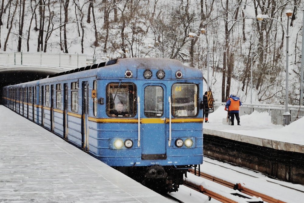 blue and black train on railroad during daytime