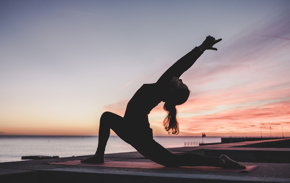 Silhouettenfotografie einer Frau, die Yoga macht