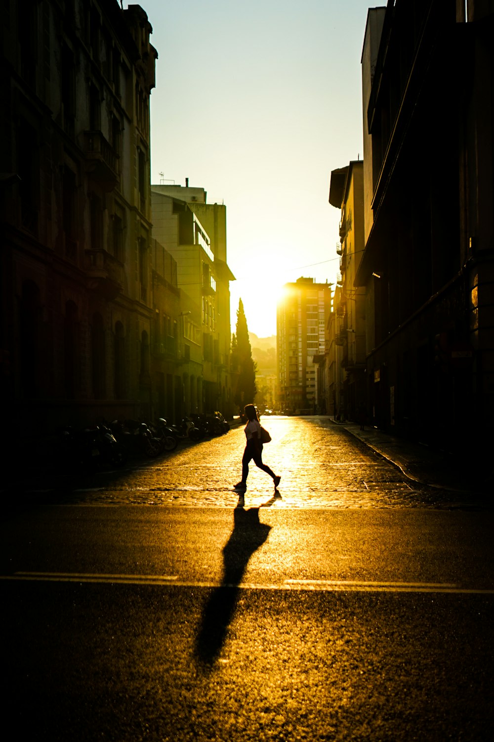 person crossing street between buildings