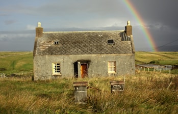gray concrete house on lawn field during daytime