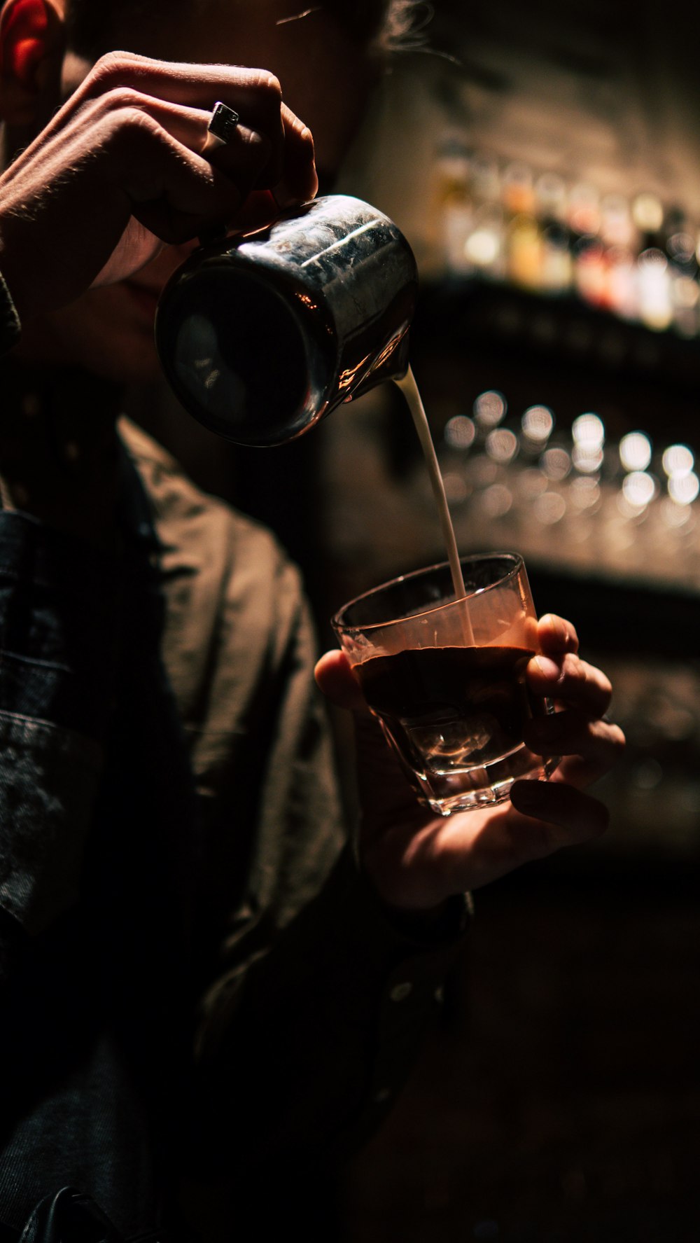 man pouring content on drinking glass