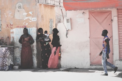 women standing beside white concrete wall senegal teams background