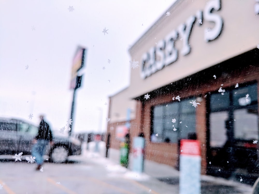 man walking to the car in front of Casey's building during daytime