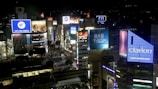 A vibrant cityscape with illuminated billboards and digital advertisements.
