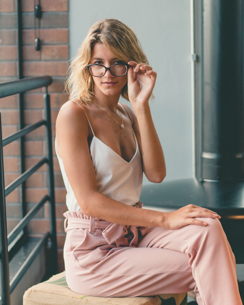 woman in eyeglasses,white spaghetti strap v-neck top and peach-colored drawstring pants