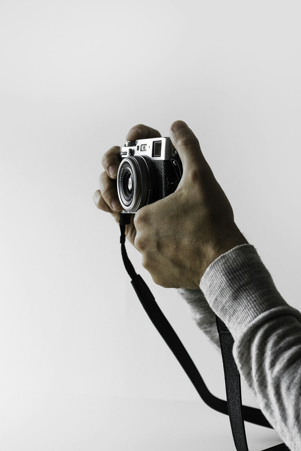 Persona sosteniendo una cámara gris y negra