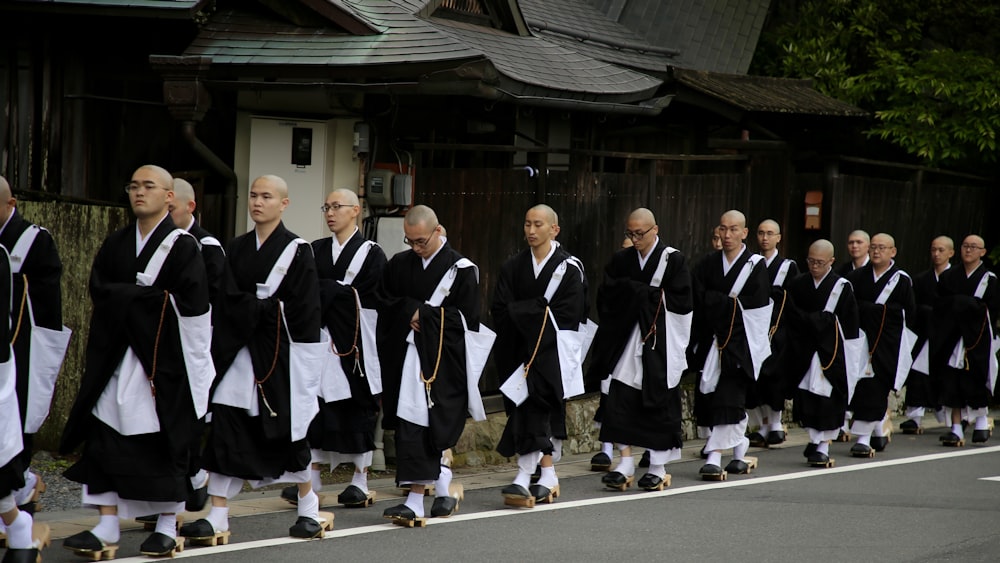 monks lining up on road during daytime