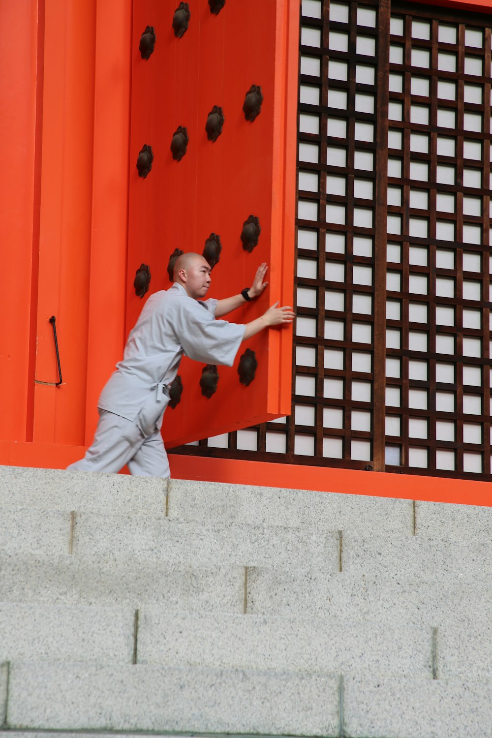 man holding orange wooden door during daytime