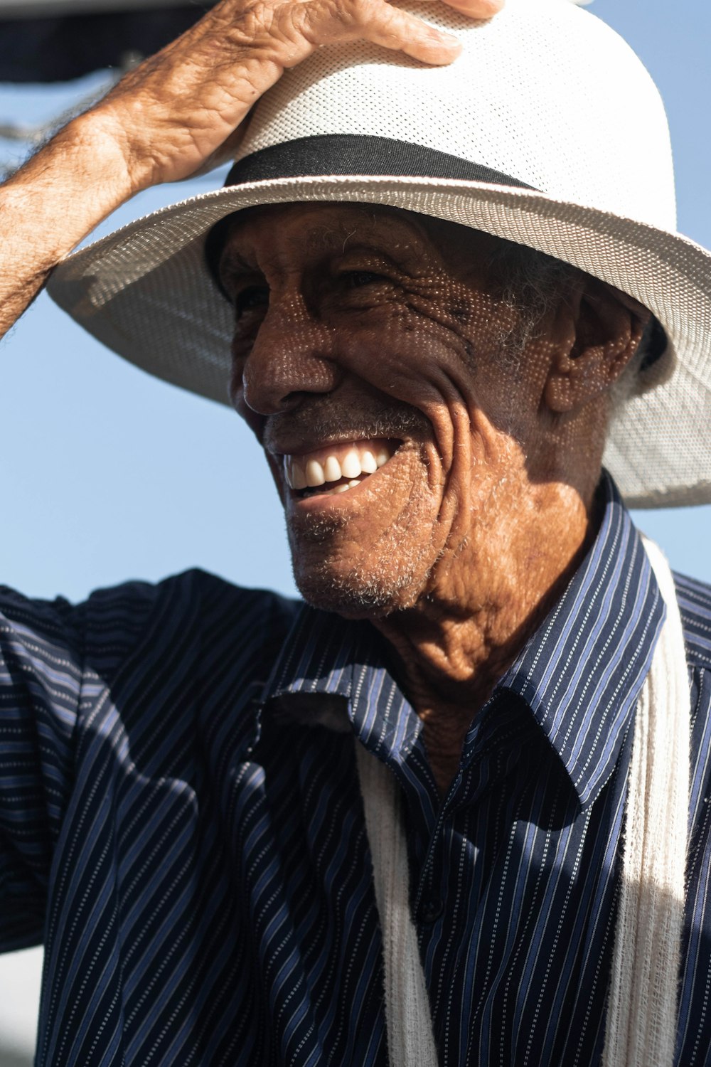 smiling man holds white hat