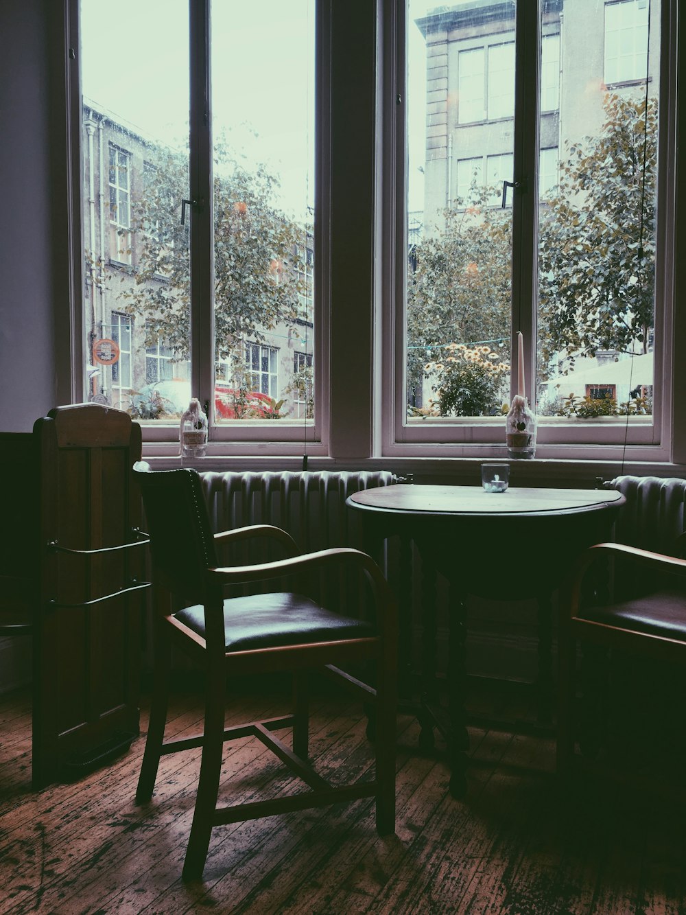 dining table and chairs beside windowpane