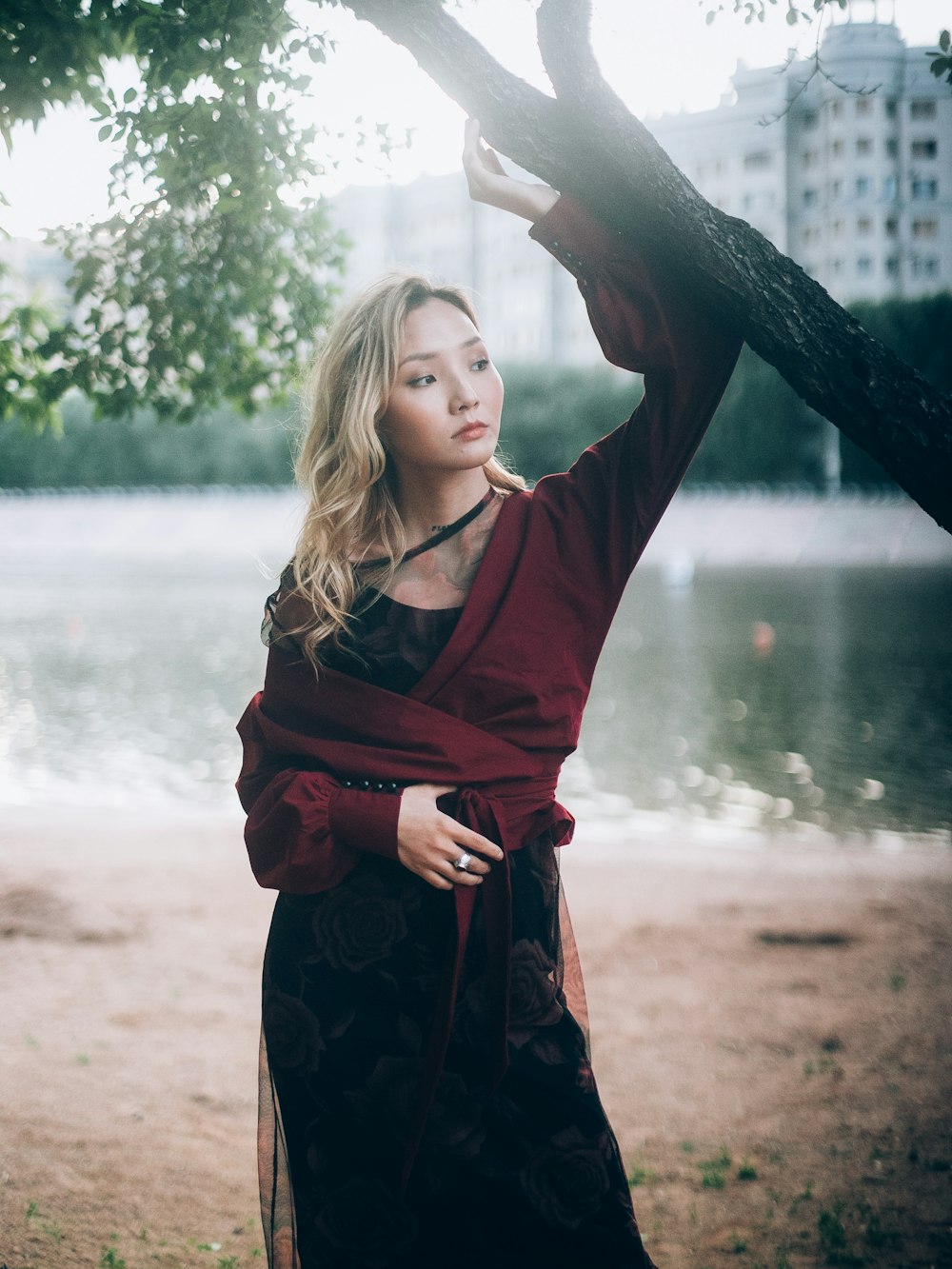 woman standing under tree near lake