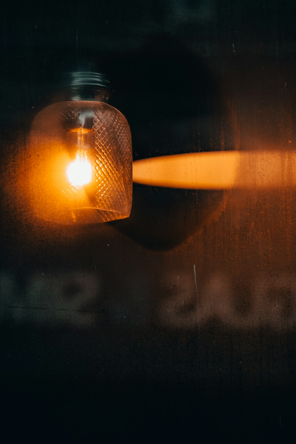 turned-on light with glass lampshade