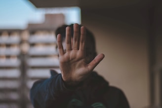 Person mit erhobener Hand als Abwehrgeste